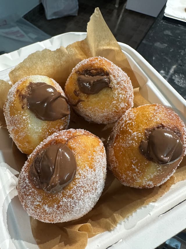 Eggless bombolinis, filled Italian doughnuts rolled in sugar